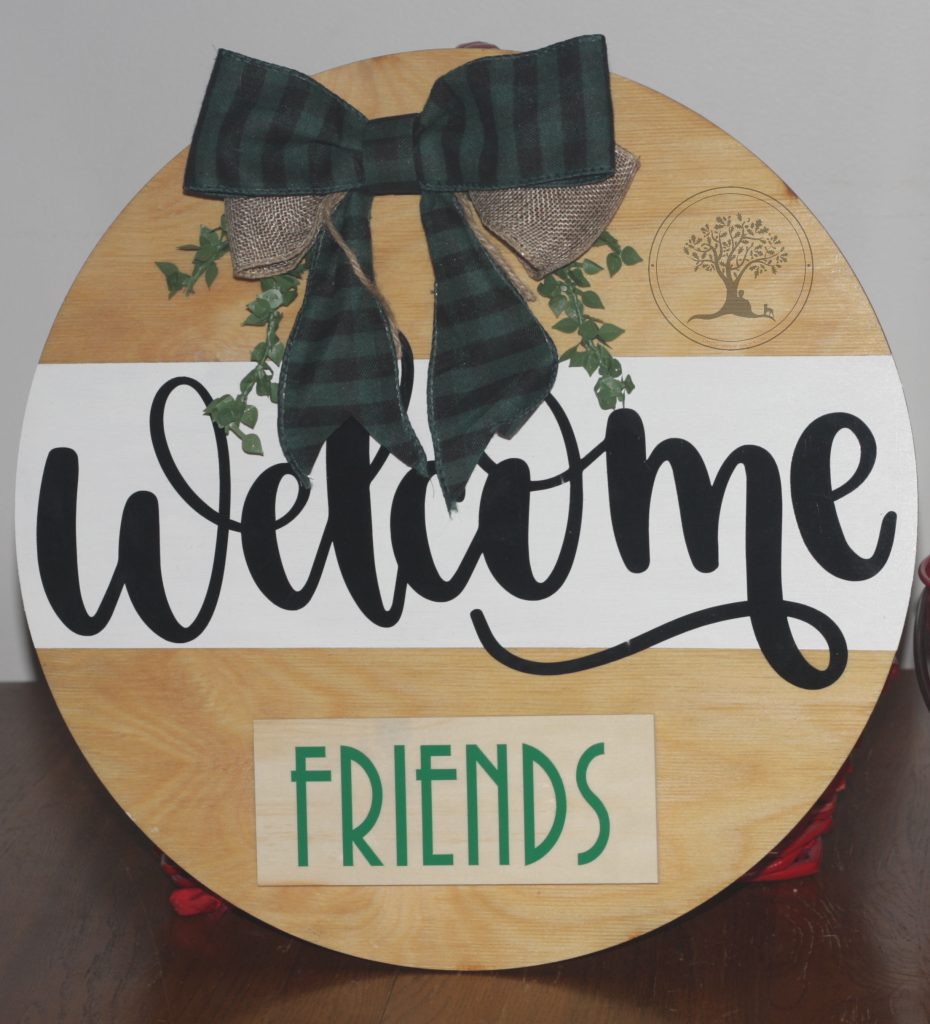 Welcome friends round sign with green gingham bow